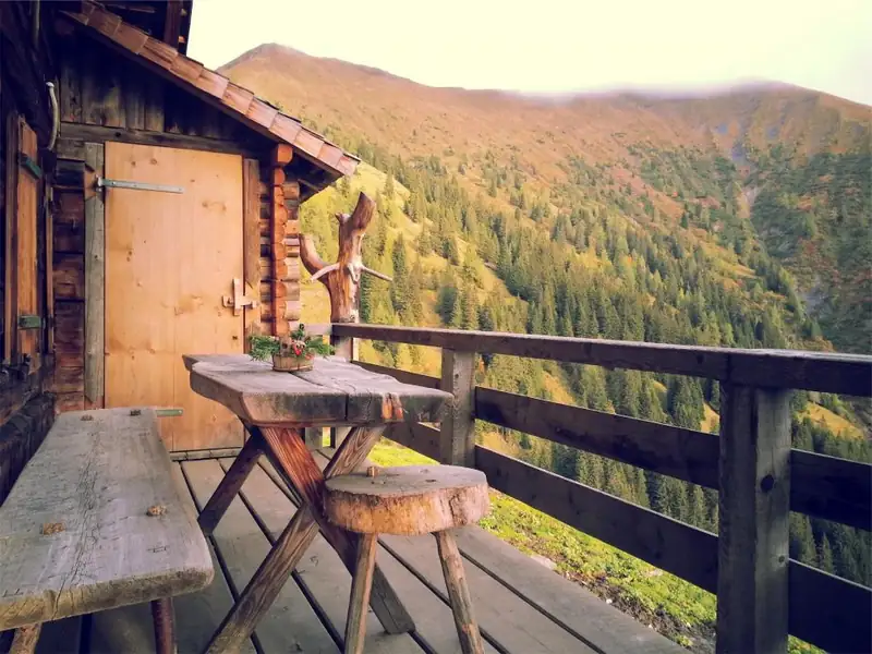 A cabin deck looking out over a forested valley